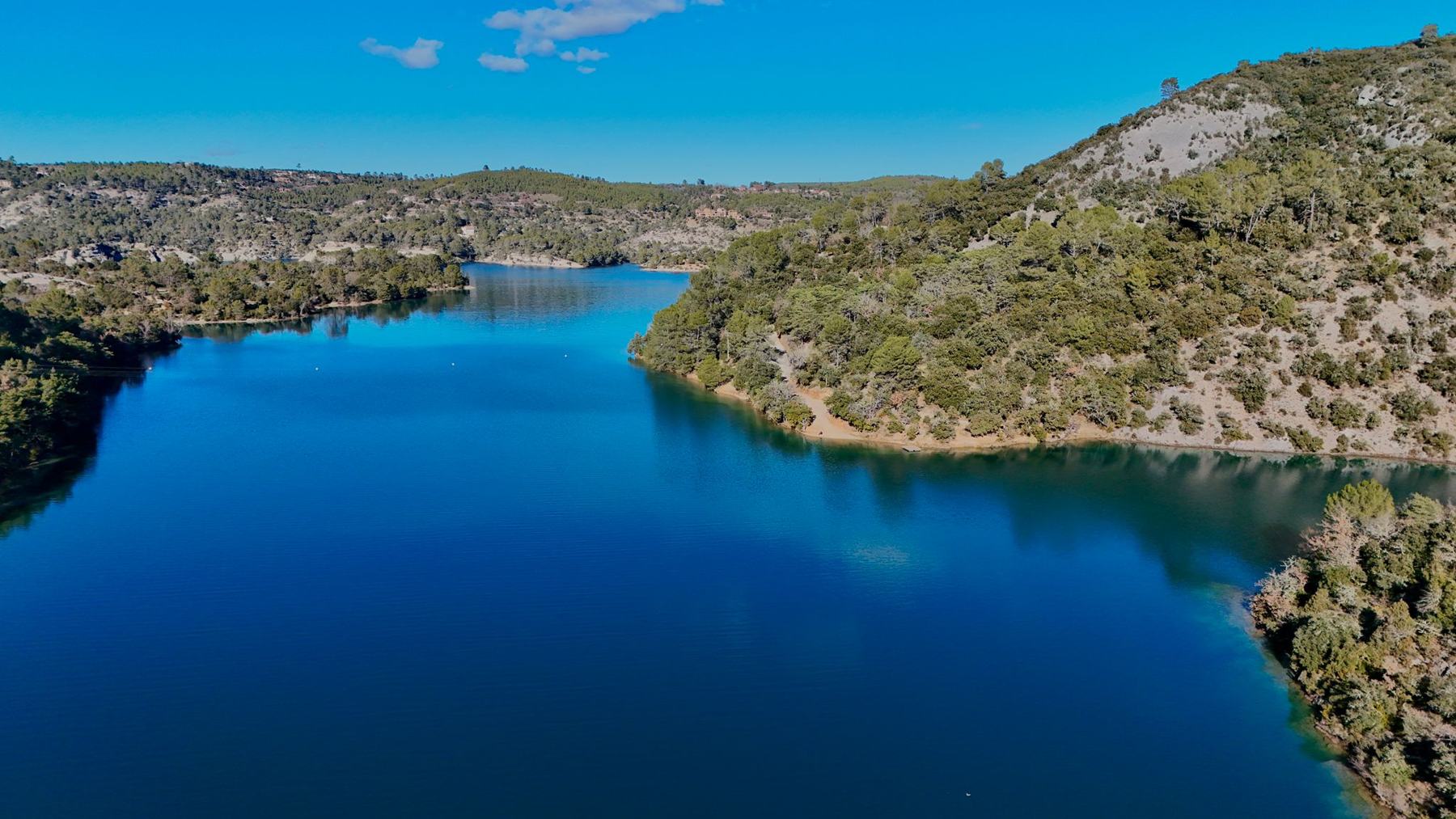 Un lac du Verdon, eau bleu profond entre des collines de chênes verts et de pins