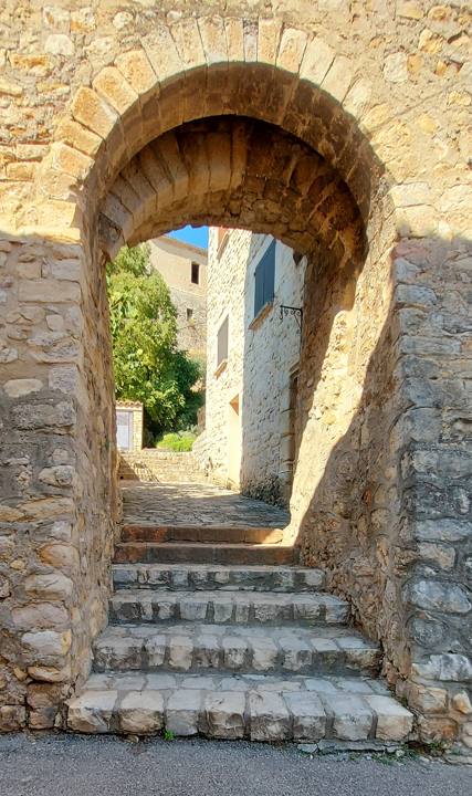 Porte voûtée en pierre et escalier d'une ruelle du vieux village